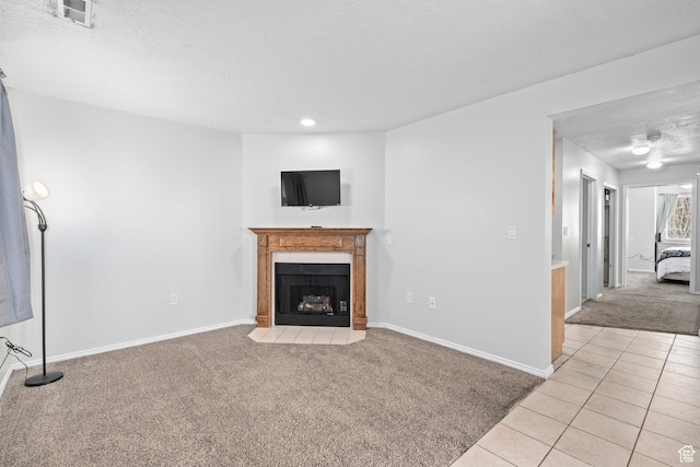 137 W 600 N Unit 205, Tooele, UT 84074 - unfurnished living room featuring baseboards, a fireplace with flush hearth, light tile patterned flooring, a textured ceiling, and light colored carpet