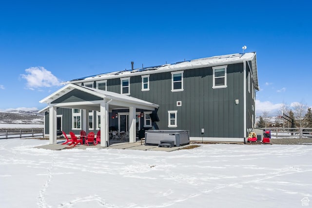 165 E Wasatch Way, Snyderville, UT 84098 - snow covered house featuring board and batten siding, a hot tub, a patio, and fence