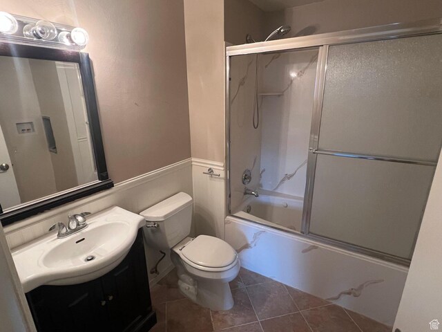 916 E Sunburn Ln, Sandy, UT 84094 - full bath with tile patterned floors, combined bath / shower with glass door, toilet, and vanity