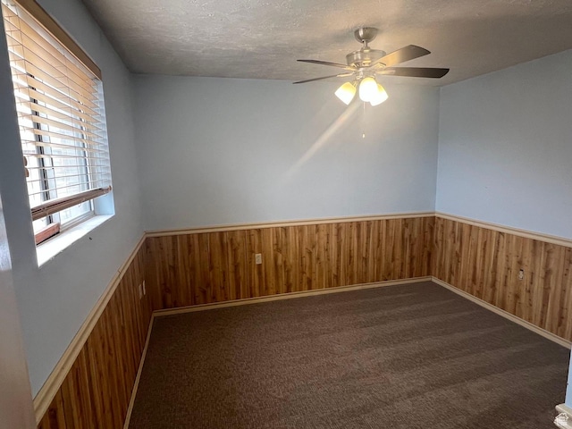916 E Sunburn Ln, Sandy, UT 84094 - unfurnished room with a ceiling fan, a textured ceiling, wooden walls, carpet flooring, and wainscoting