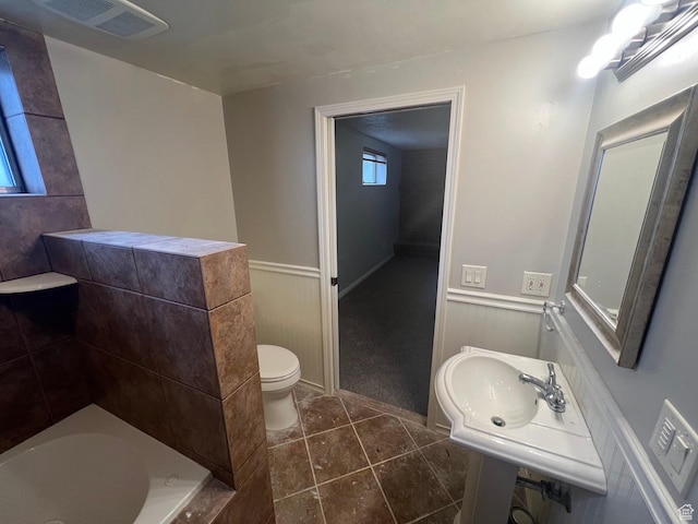 916 E Sunburn Ln, Sandy, UT 84094 - full bathroom with visible vents, a wainscoted wall, toilet, a bathing tub, and tile patterned floors