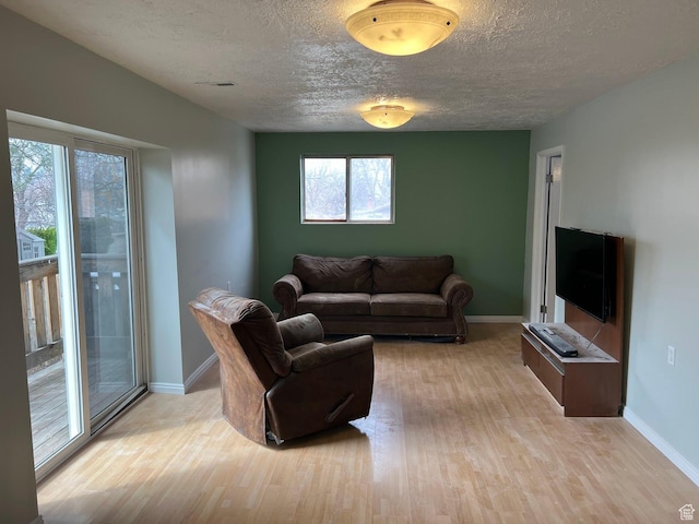 916 E Sunburn Ln, Sandy, UT 84094 - living room featuring baseboards, a textured ceiling, and light wood-style floors