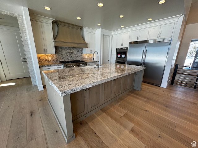 3151 E 5225 N Unit 11, Liberty, UT 84310 - kitchen featuring custom exhaust hood, built in fridge, white cabinets, light wood finished floors, and a sink