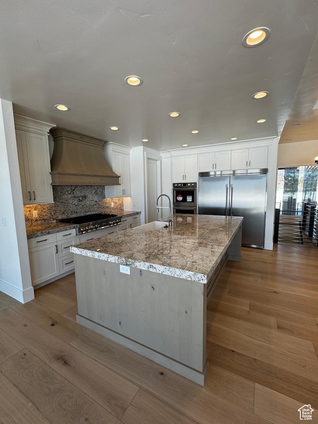 3151 E 5225 N Unit 11, Liberty, UT 84310 - kitchen featuring tasteful backsplash, a large island, appliances with stainless steel finishes, a sink, and custom range hood