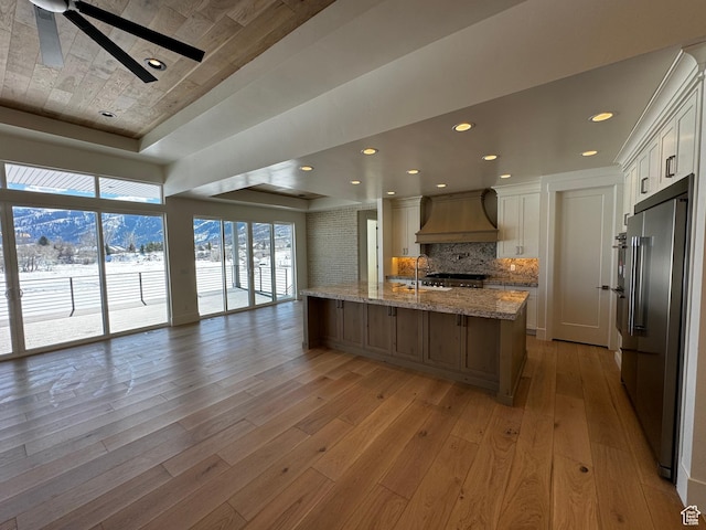 3151 E 5225 N Unit 11, Liberty, UT 84310 - kitchen featuring custom range hood, a ceiling fan, backsplash, light wood finished floors, and high quality fridge