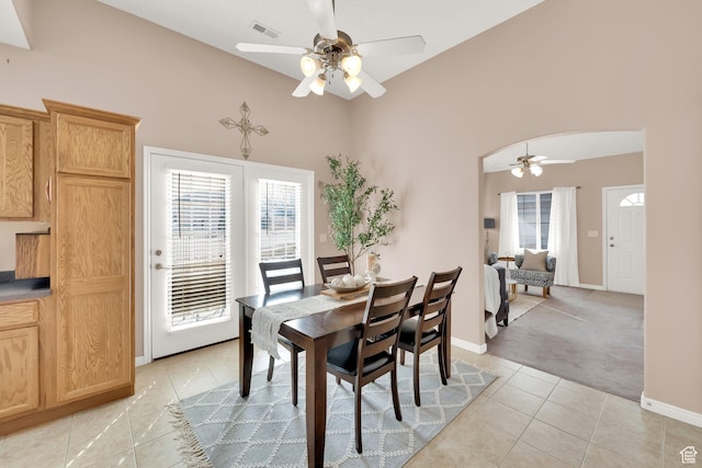 8851 S Humboldt Ct W, West Jordan, UT 84081 - dining area with a ceiling fan, light tile patterned floors, arched walkways, vaulted ceiling, and light carpet