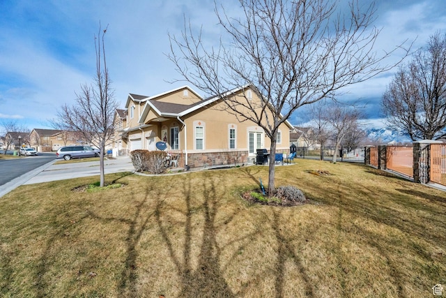 view of side of home with fence, stucco siding, a lawn, a garage, and driveway