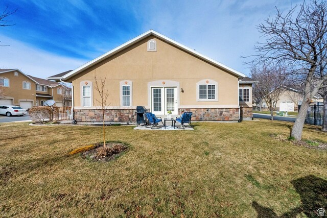 8851 S Humboldt Ct W, West Jordan, UT 84081 - back of house featuring stone siding, stucco siding, a yard, and a patio area