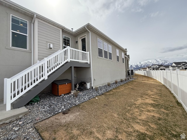 view of home's exterior with stairway and fence
