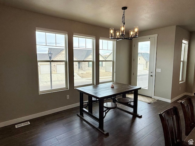 dining area with visible vents, dark wood-type flooring, a notable chandelier, and baseboards