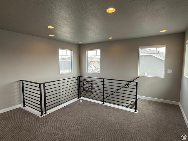 carpeted spare room featuring recessed lighting, baseboards, and a textured ceiling