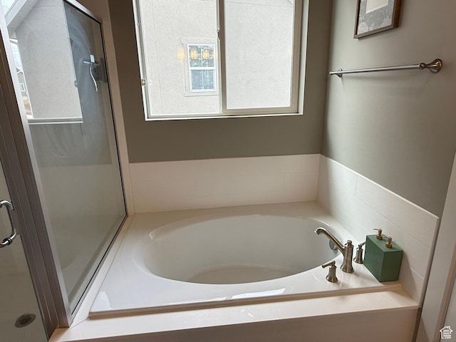 bathroom with a bath and a shower stall