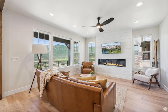 6005 N Westridge Rd, Heber City, UT 84032 - living area featuring light wood finished floors, baseboards, ceiling fan, and a large fireplace
