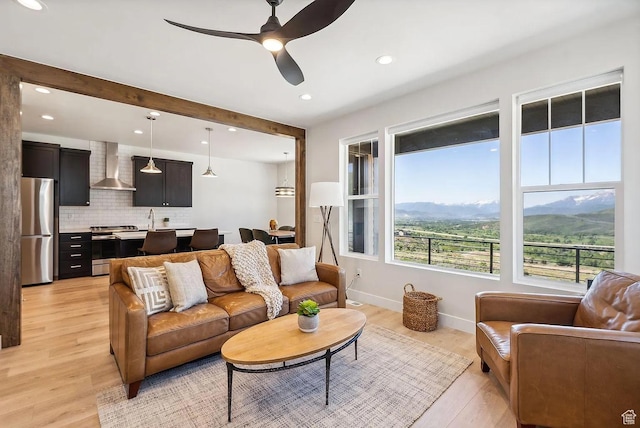 6005 N Westridge Rd, Heber City, UT 84032 - living room with baseboards, beamed ceiling, ceiling fan, and light wood-type flooring