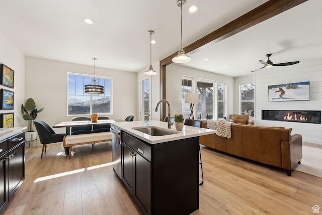 6005 N Westridge Rd, Heber City, UT 84032 - kitchen with light countertops, a sink, dishwasher, open floor plan, and light wood-style floors