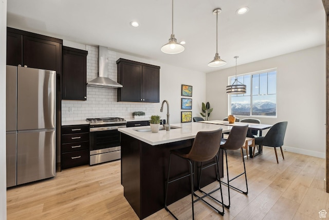 6005 N Westridge Rd, Heber City, UT 84032 - kitchen featuring light countertops, backsplash, light wood-type flooring, stainless steel appliances, and wall chimney range hood
