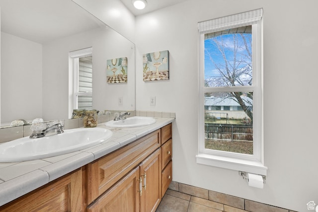 full bath featuring double vanity, tile patterned flooring, and a sink