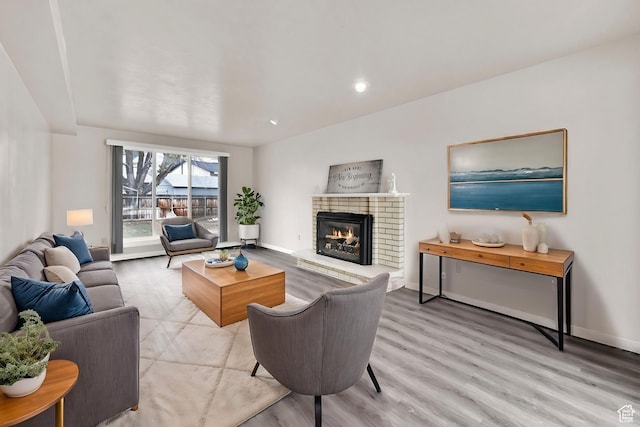 living room with baseboards, a fireplace, and wood finished floors