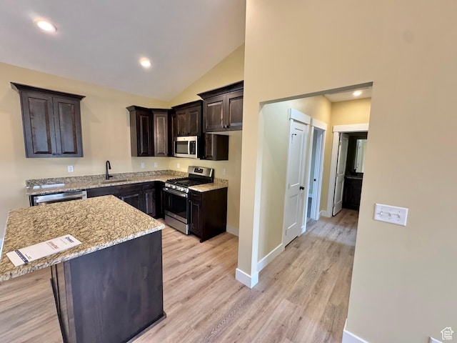 18136 N 6000 W, Garland, UT 84312 - kitchen featuring light wood-style flooring, light stone counters, a kitchen island, appliances with stainless steel finishes, and dark brown cabinets