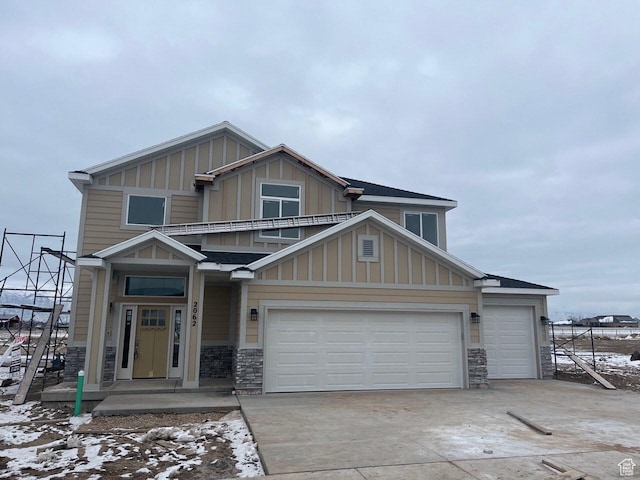 3999 W 2025 S Unit 45, Taylor, UT 84401 - view of front of property featuring stone siding, board and batten siding, concrete driveway, and an attached garage