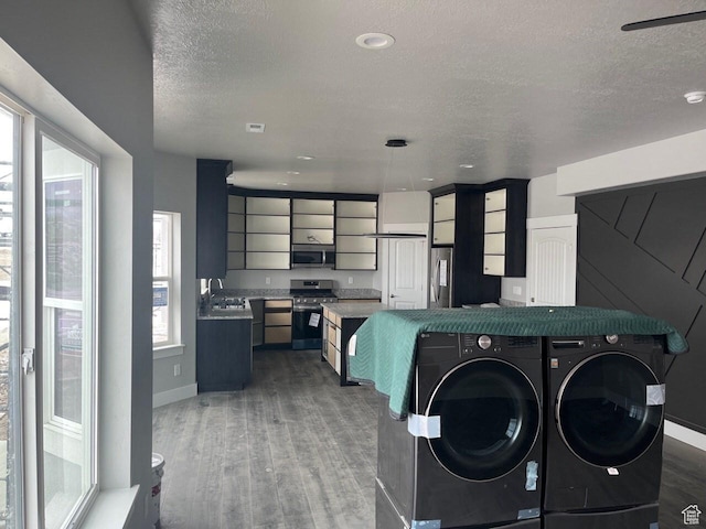 3999 W 2025 S Unit 45, Taylor, UT 84401 - clothes washing area with independent washer and dryer, a textured ceiling, baseboards, and wood finished floors