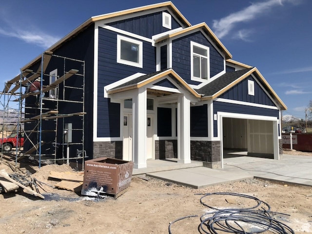 3999 W 2025 S Unit 45, Taylor, UT 84401 - view of front of home featuring driveway, a garage, board and batten siding, and stone siding