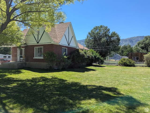 view of yard featuring a mountain view and fence