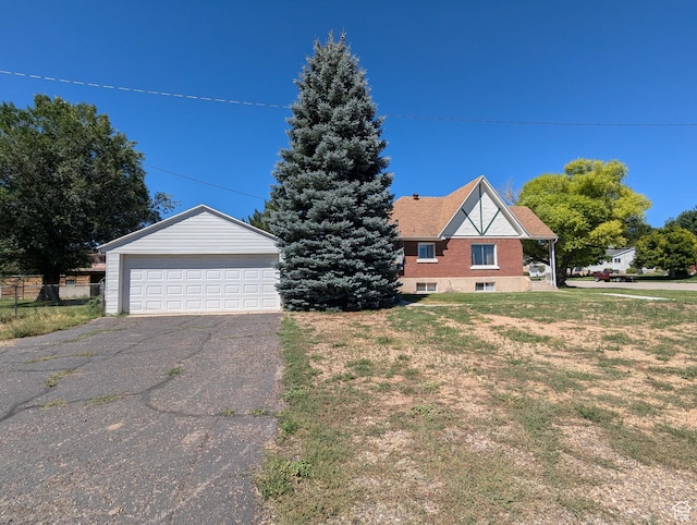 view of front of home featuring a front yard, a garage, and an outdoor structure
