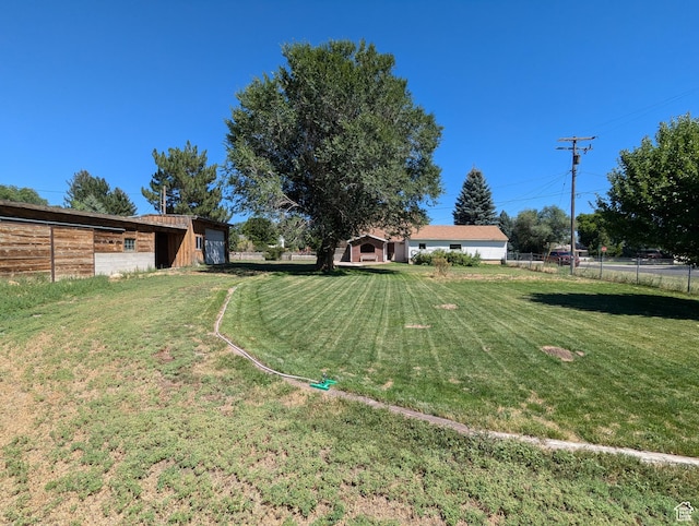 view of yard featuring an outdoor structure and fence