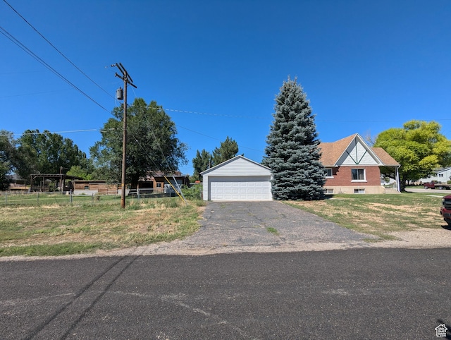 view of front of house featuring an outbuilding, a detached garage, and fence