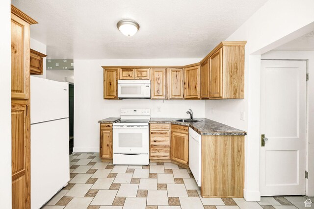 260 W 300 S, Hyrum, UT 84319 - kitchen with white appliances, a sink, dark countertops, light flooring, and baseboards