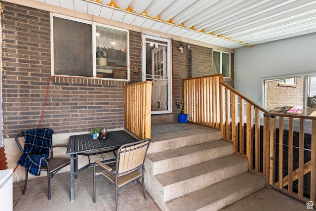 exterior space featuring outdoor dining area, a patio area, and brick siding
