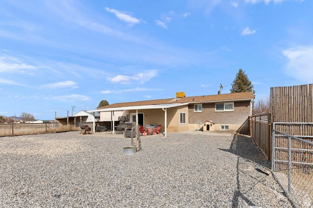rear view of property featuring a patio and a fenced backyard