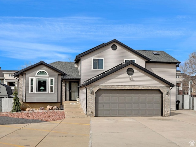 view of front of property featuring an attached garage, concrete driveway, and fence