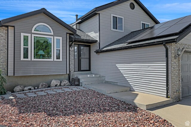 1778 Allison Way, Syracuse, UT 84075 - view of front of property featuring an attached garage, roof mounted solar panels, and roof with shingles