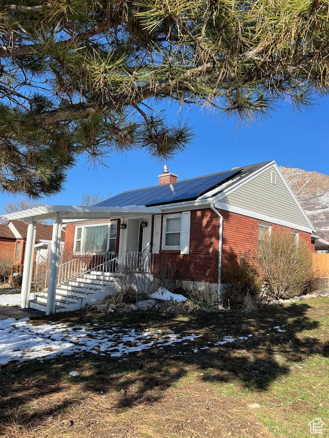 3614 Taylor Ave, Ogden, UT 84403 - ranch-style home with roof mounted solar panels, a chimney, and brick siding