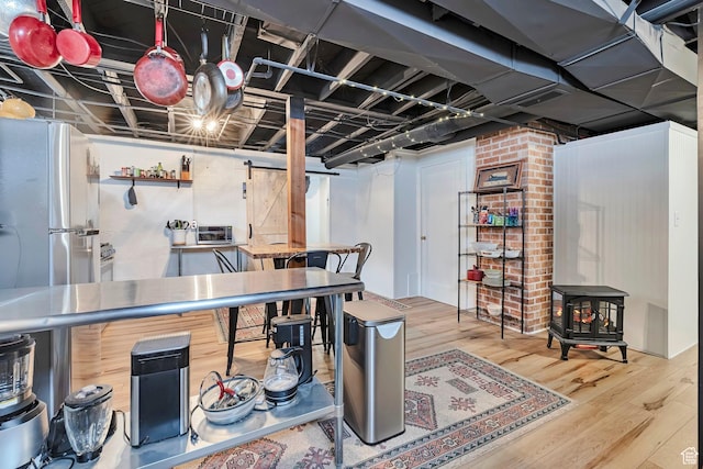 3614 Taylor Ave, Ogden, UT 84403 - finished below grade area featuring wood finished floors, a wood stove, and freestanding refrigerator