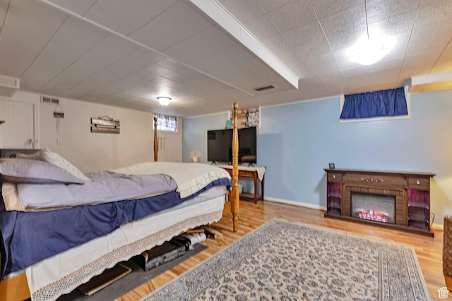 3614 Taylor Ave, Ogden, UT 84403 - bedroom featuring wood finished floors, a warm lit fireplace, and baseboards
