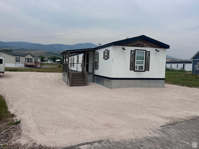 631 S Maple Dr, Garden City, UT 84028 - manufactured / mobile home with a porch, cooling unit, a mountain view, and driveway