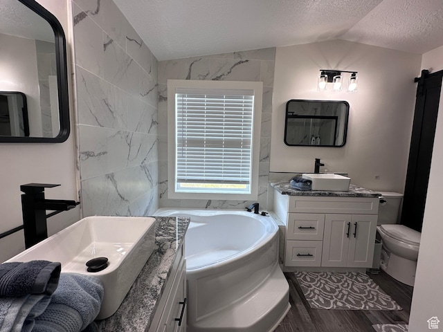 631 S Maple Dr, Garden City, UT 84028 - bathroom with a garden tub, two vanities, a sink, a textured ceiling, and lofted ceiling