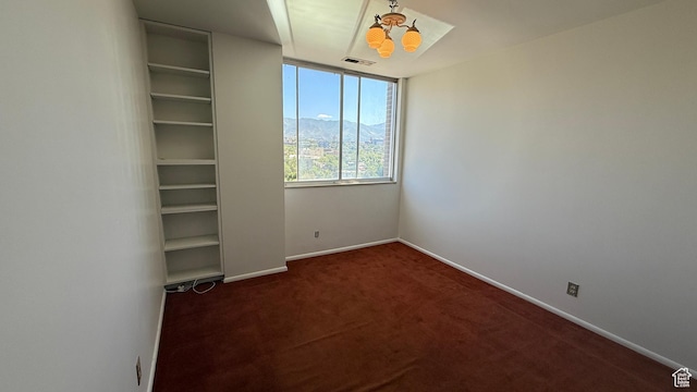 777 E S Temple Unit 13A, Salt Lake City, UT 84102 - empty room with a chandelier, dark carpet, and baseboards
