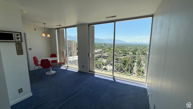 777 E S Temple Unit 13A, Salt Lake City, UT 84102 - empty room with a mountain view, expansive windows, a chandelier, and baseboards