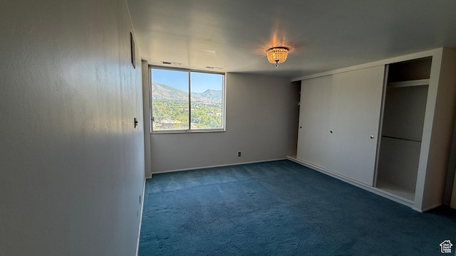 777 E S Temple Unit 13A, Salt Lake City, UT 84102 - unfurnished bedroom featuring dark colored carpet, baseboards, a mountain view, and a closet