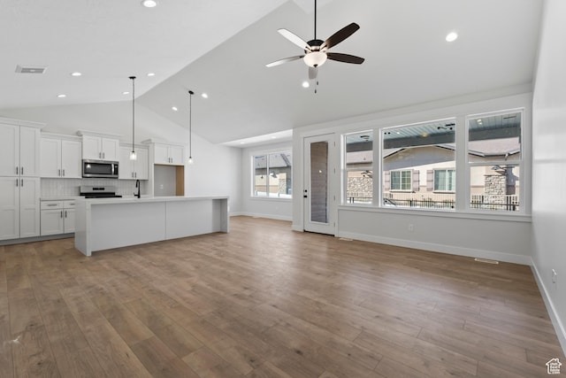 5336 S Murray Rd Unit 115, Murray, UT 84123 - kitchen with backsplash, open floor plan, appliances with stainless steel finishes, white cabinetry, and a ceiling fan