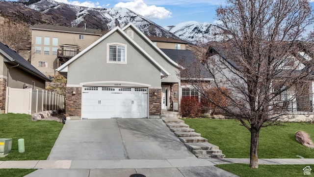 traditional home with stucco siding, a front lawn, stone siding, fence, and concrete driveway