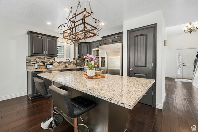 10358 N Tamarack Way E, Cedar Hills, UT 84062 - kitchen featuring stainless steel appliances, a chandelier, a center island, dark wood-style flooring, and a breakfast bar area