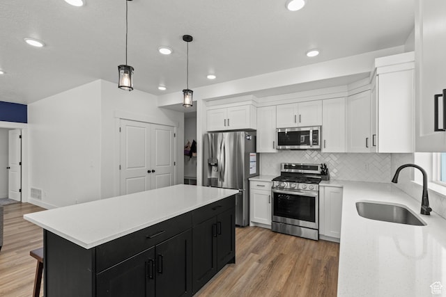 763 E 1200 S, Hyrum, UT 84319 - kitchen featuring appliances with stainless steel finishes, a sink, dark cabinets, white cabinetry, and light wood-type flooring