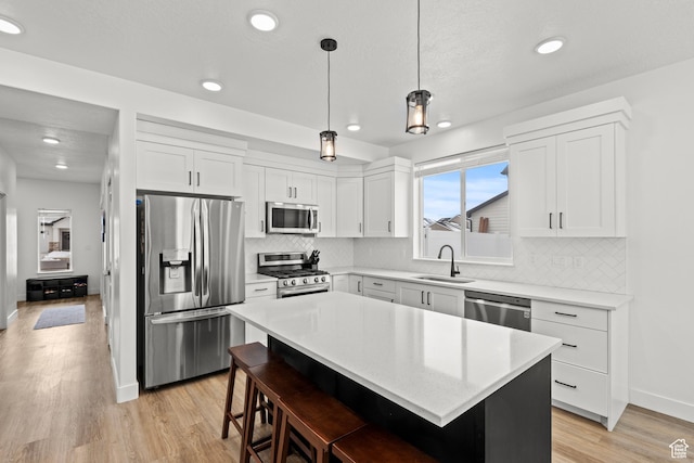 763 E 1200 S, Hyrum, UT 84319 - kitchen with appliances with stainless steel finishes, a sink, a kitchen bar, light countertops, and a center island