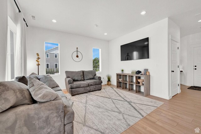 living room with visible vents, recessed lighting, baseboards, and light wood finished floors