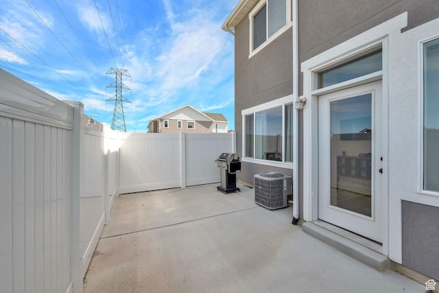 view of patio with fence and central AC